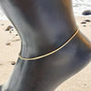 Gold filled 1m box chain shown on a model anklet on a sandy beach